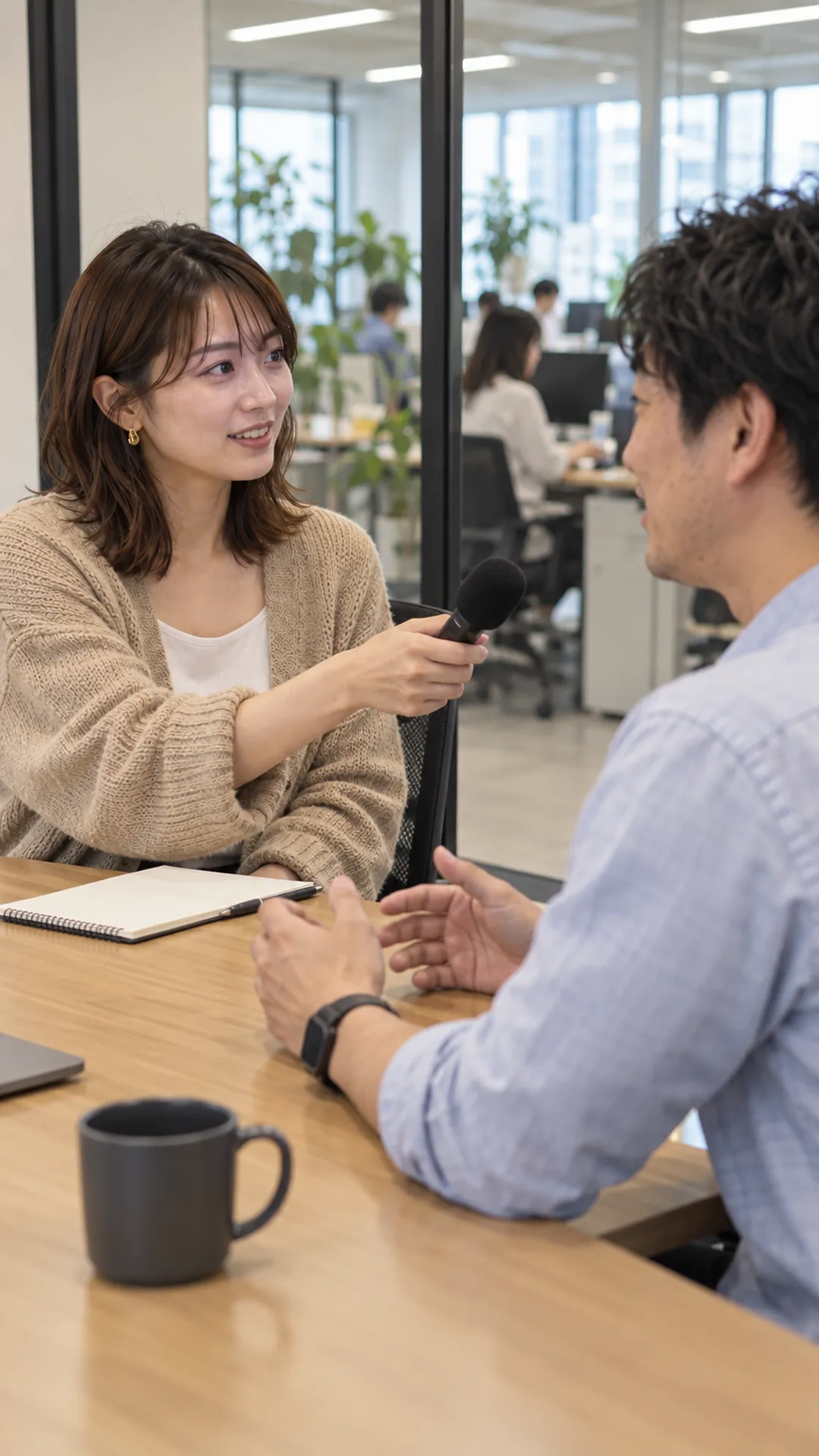 オフィスで社員に取材するタレント(撮影イメージ)
